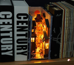 Miniature Japanese street book nook scene with warm lights and shelves in an open case