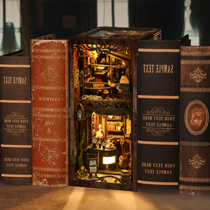 A miniature diorama of a small shop or store, constructed from books, with various objects and decorations inside the open book.