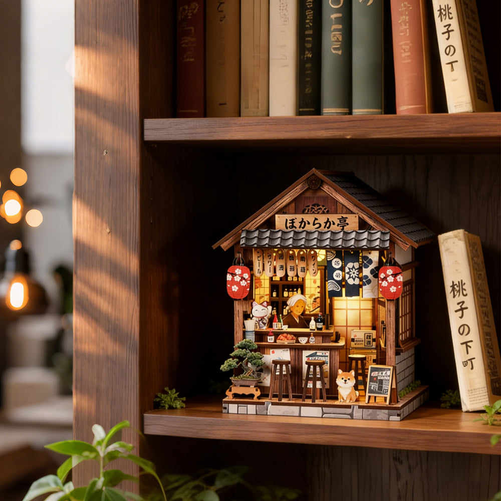 Miniature wooden pub book nook house on shelf, front view with bar stools and cat figure