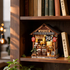 Miniature wooden pub book nook house on shelf, front view with bar stools and cat figure