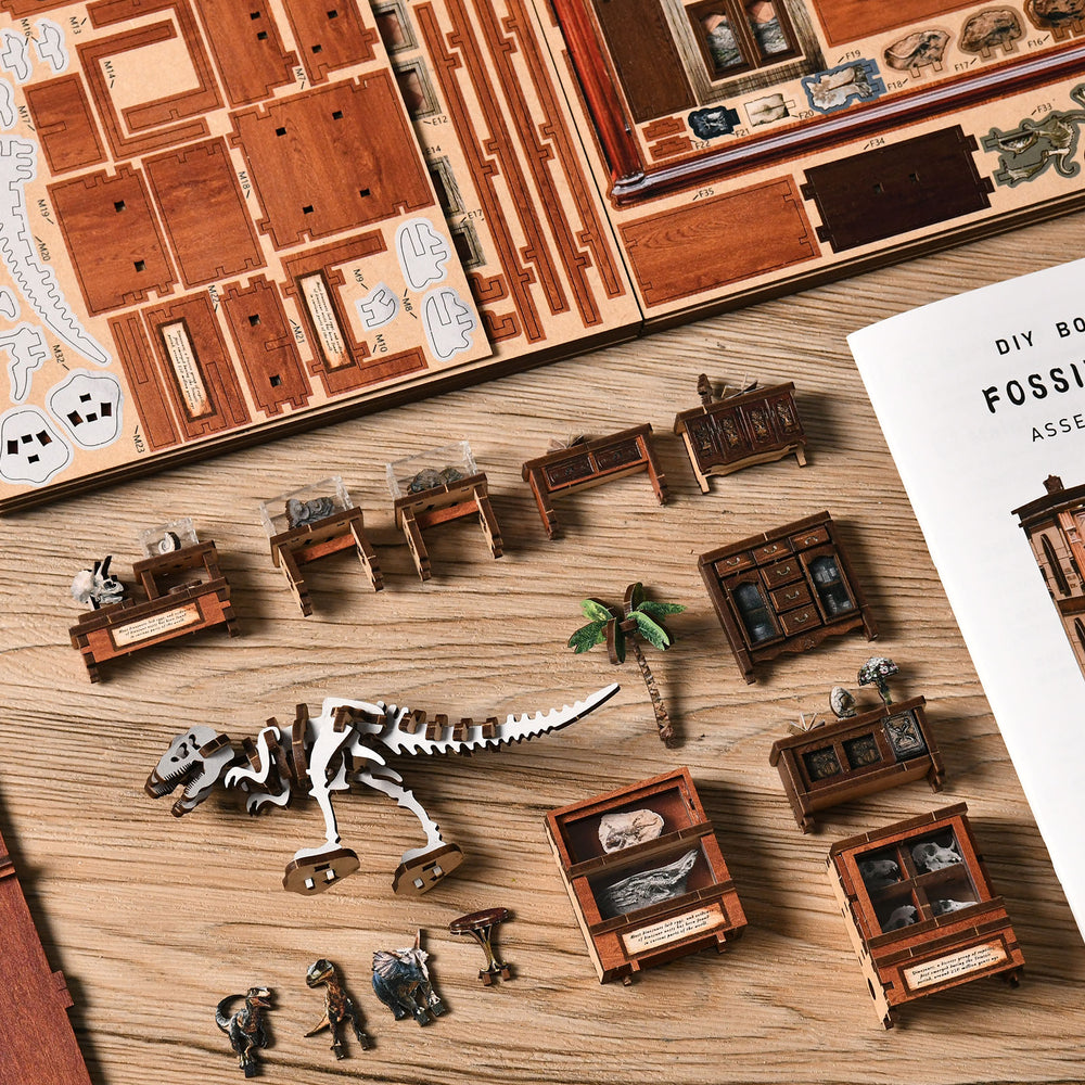 Wooden miniature kit parts laid out, including dinosaur skeleton, furniture, and mini plants