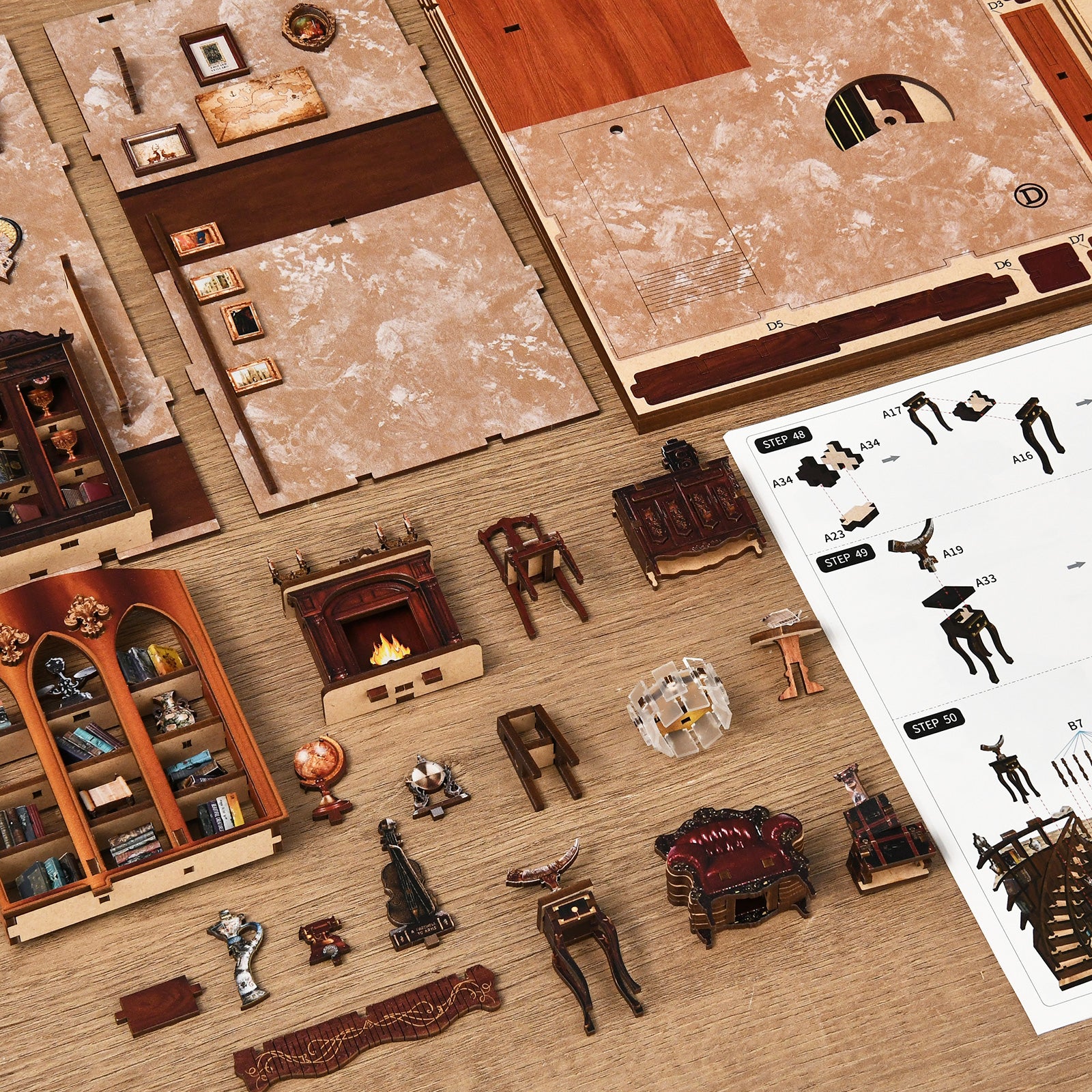 DIY miniatures kit parts laid out flat, including furniture pieces and paper inserts