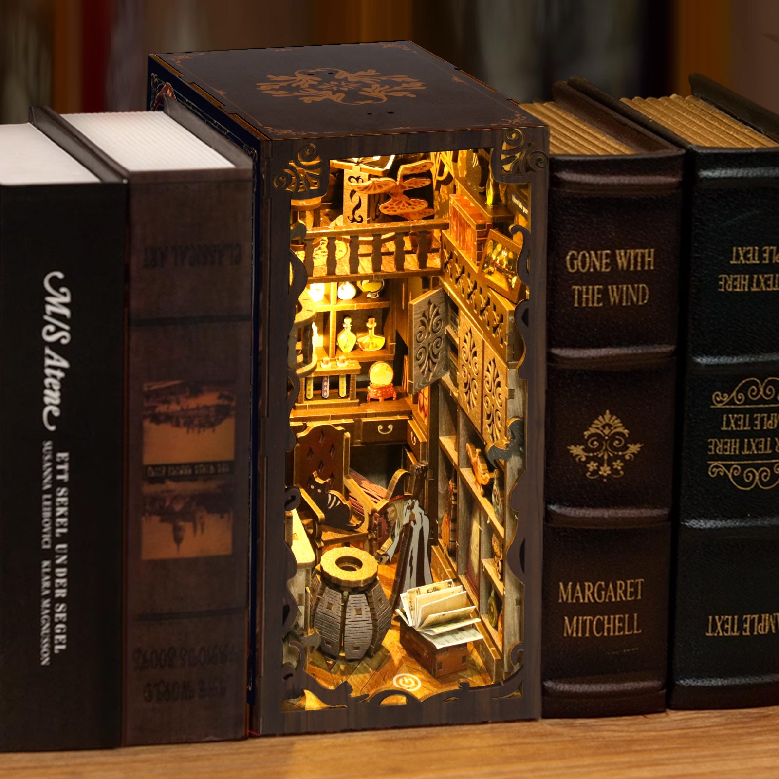 DIY book nook kit cabinet with books and miniature items in a lit interior