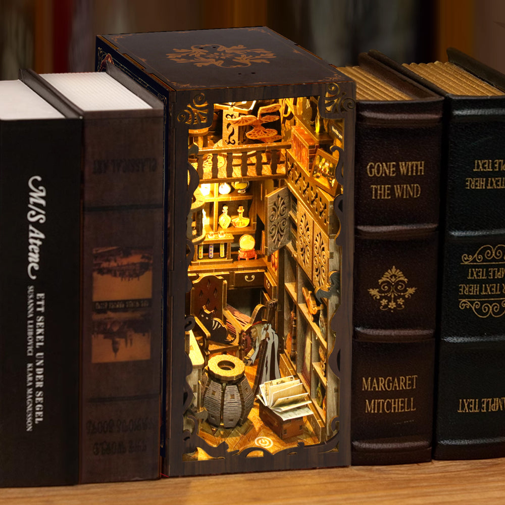 DIY book nook kit cabinet with books and miniature items in a lit interior