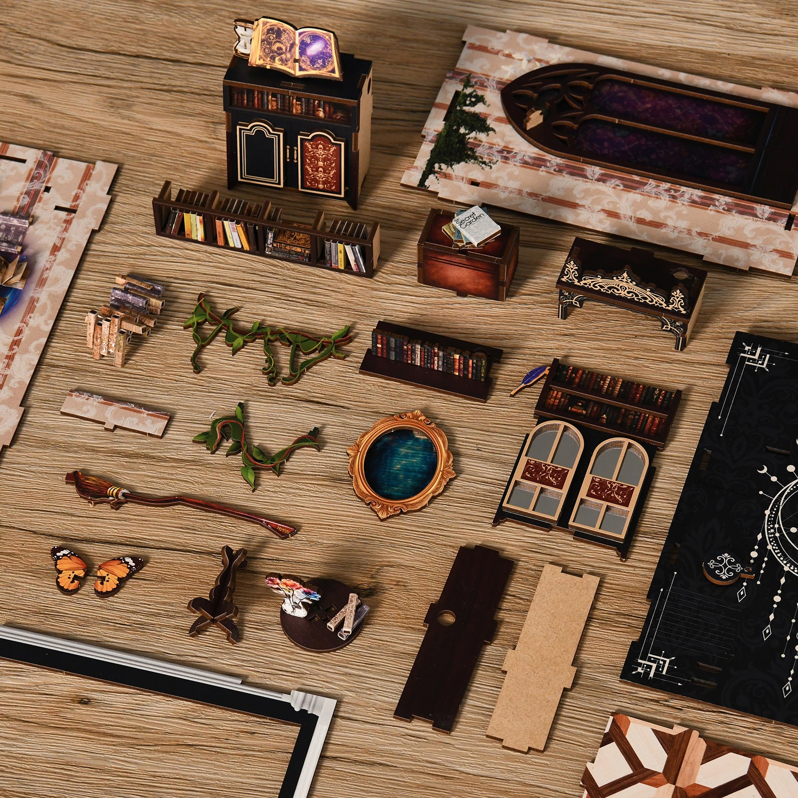 various miniature furniture and decorative items, including a bookshelf, a cabinet, a mirror, and other small objects, all arranged on a wooden surface.