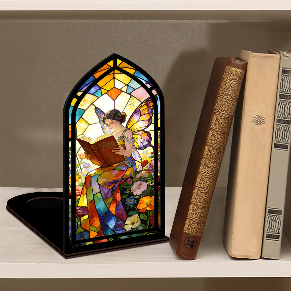 Stained glass fairy book nook with arched reading panel in black frame, books beside it