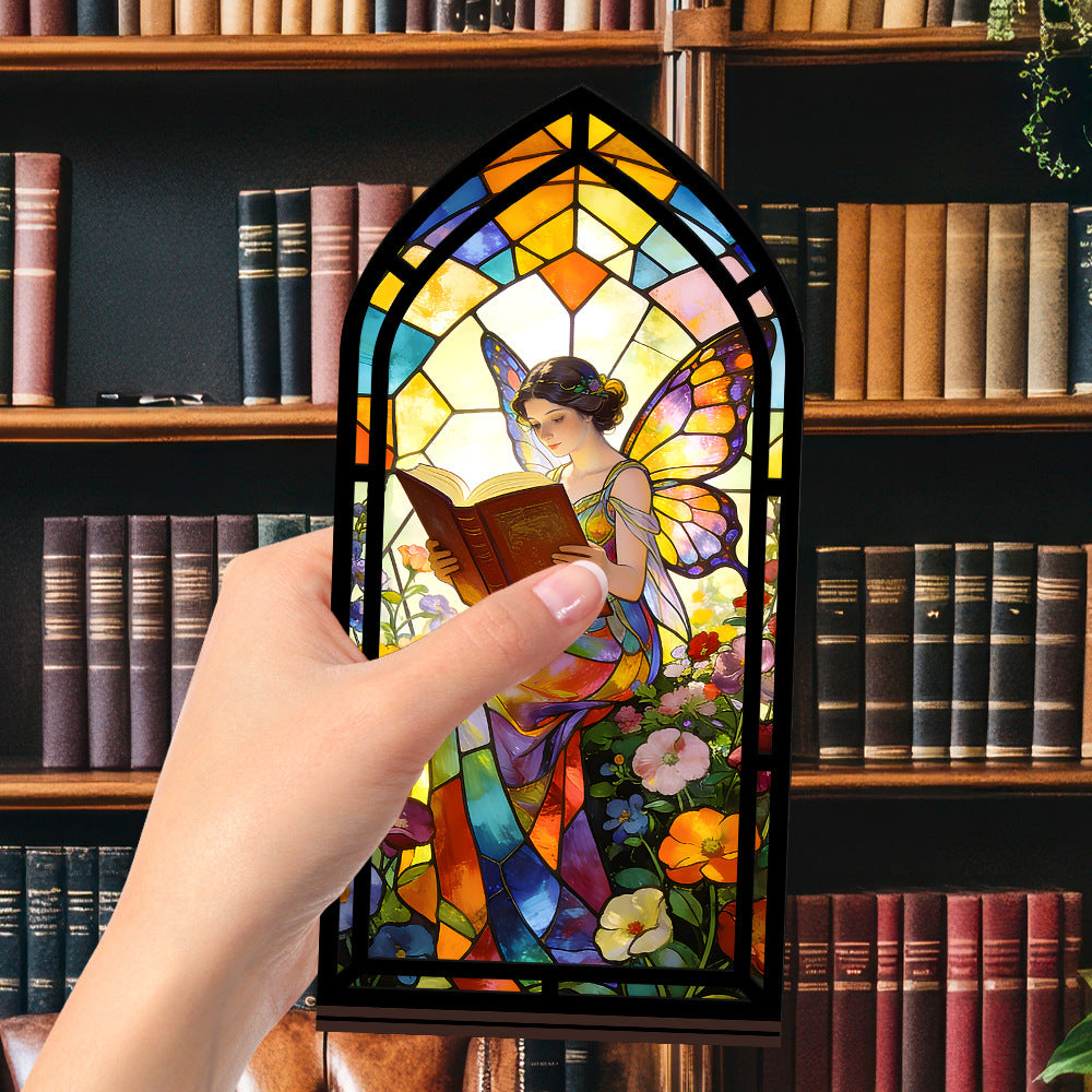 Stained glass fairy book nook panel with arched design and reading figure, black frame close-up