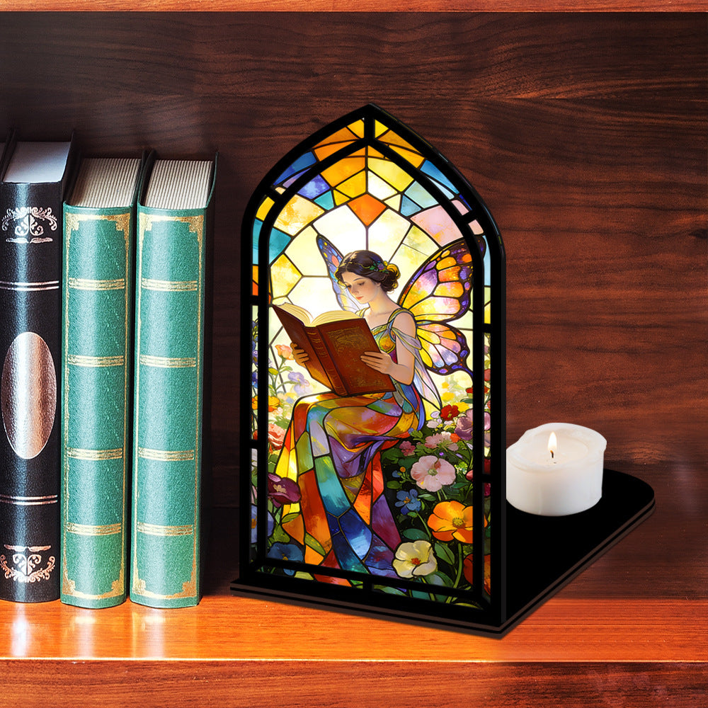 Stained glass fairy book nook with arched reading panel, black frame, candle on dark base