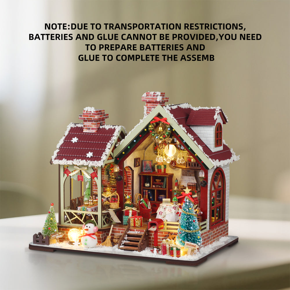 Cozy Christmas miniature dollhouse with lit interior on base, red roof, and snow trim
