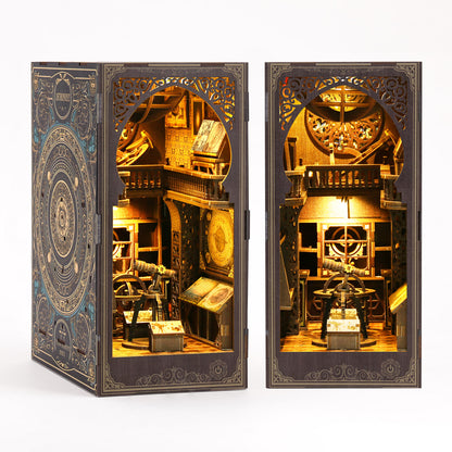 a miniature diorama or model of a room with various objects, including a clock, books, and other decorative elements, all illuminated by a warm, golden light.