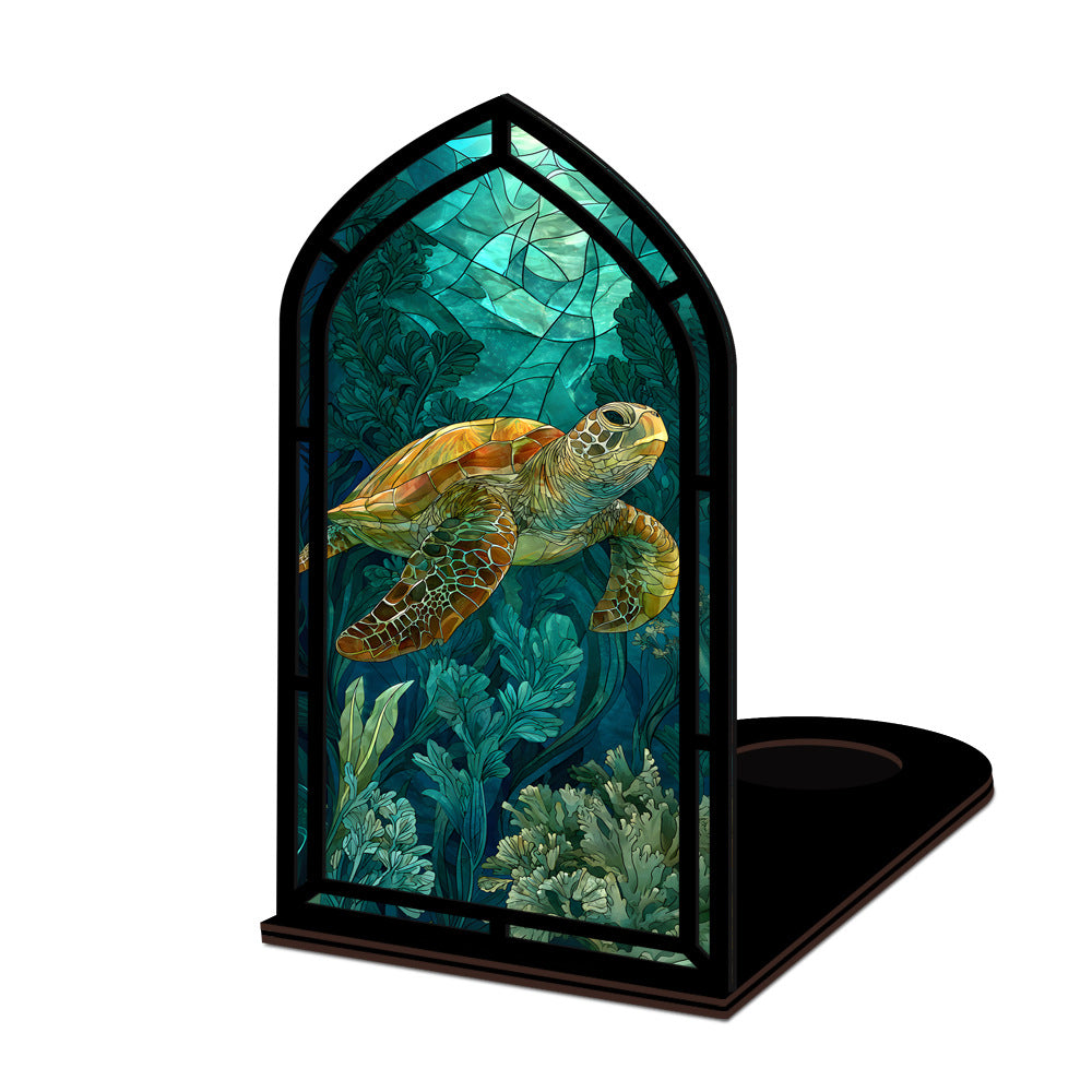 Book nook display with green sea turtle panel and black arched frame on a base