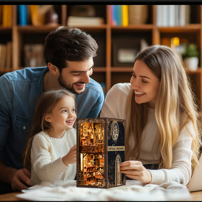 A family of three - a man, a woman, and a young girl - are gathered around a table, smiling and looking at a miniature dollhouse together.