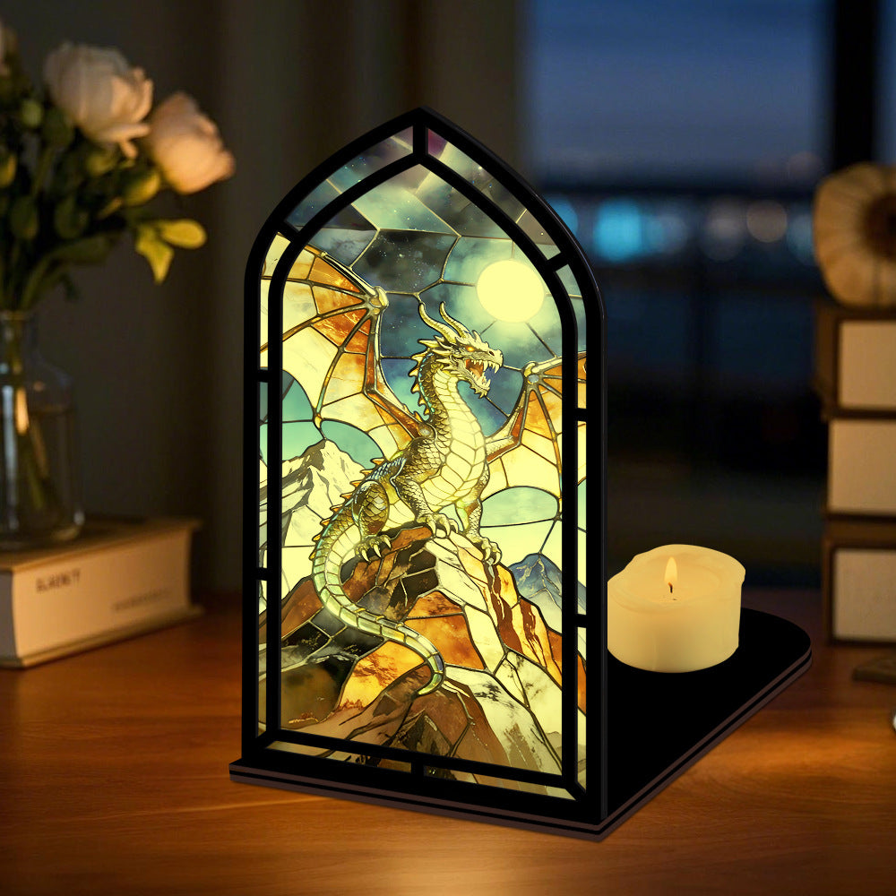 Arched stained-glass dragon book nook stand with black frame and lit candle on base