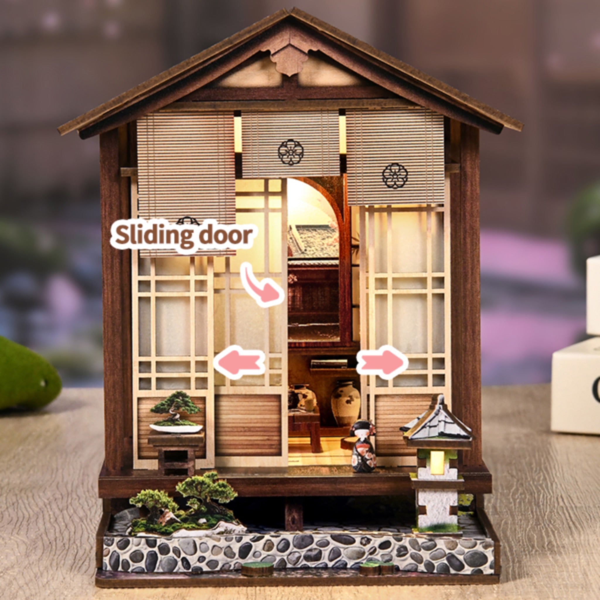 Wooden mini book nook house with sliding front door, glowing interior, and lantern light