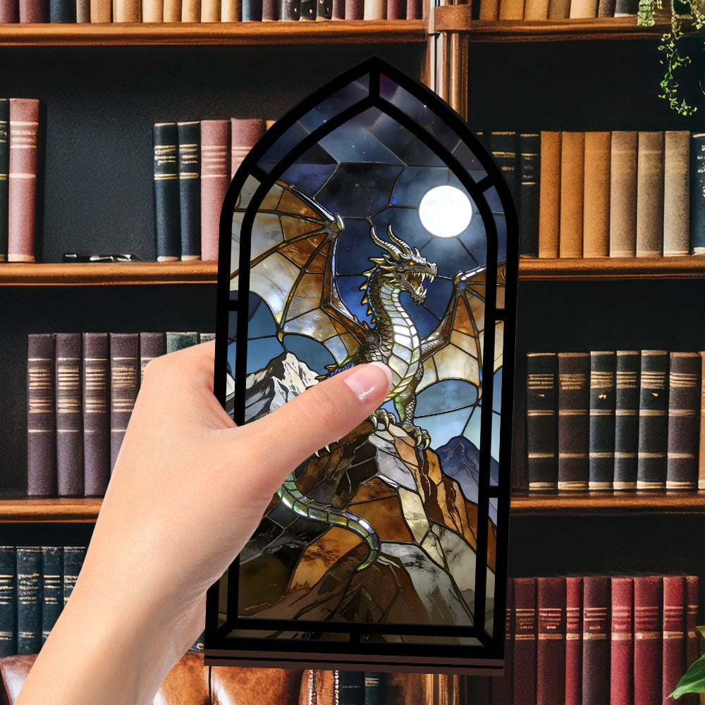 Arched stained-glass dragon book nook stand with black frame, held by a hand
