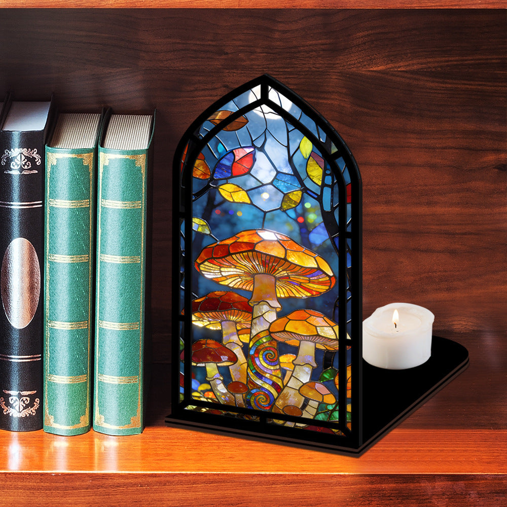 Mushroom stained-glass book nook with arched panel and multicolor mushroom scene beside candle