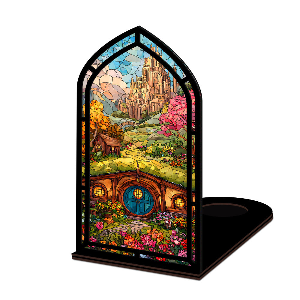 Arched book nook display with colorful illustrated panel and lit candle on a black base.