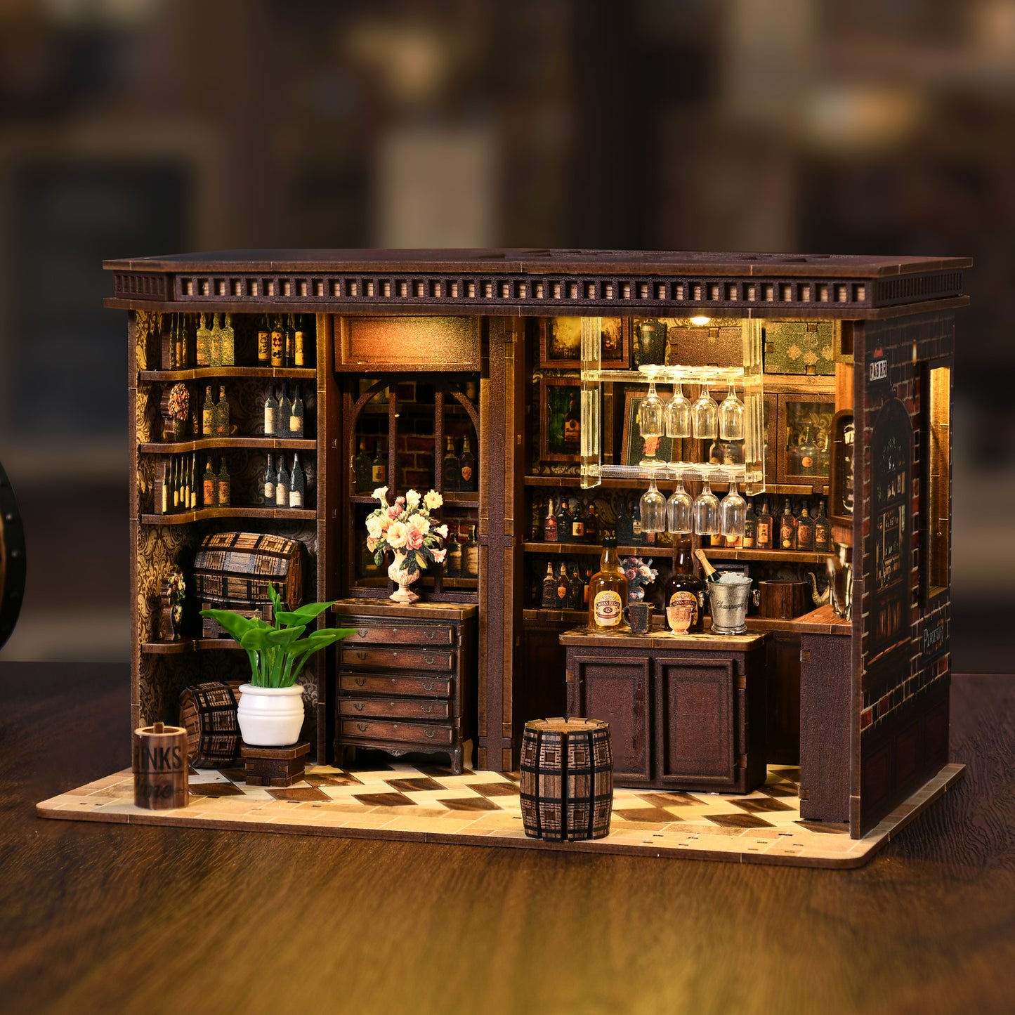 A miniature model of a bar or liquor store, featuring shelves filled with various bottles, a bar counter with wine glasses, and decorative elements such as a vase and potted plants.