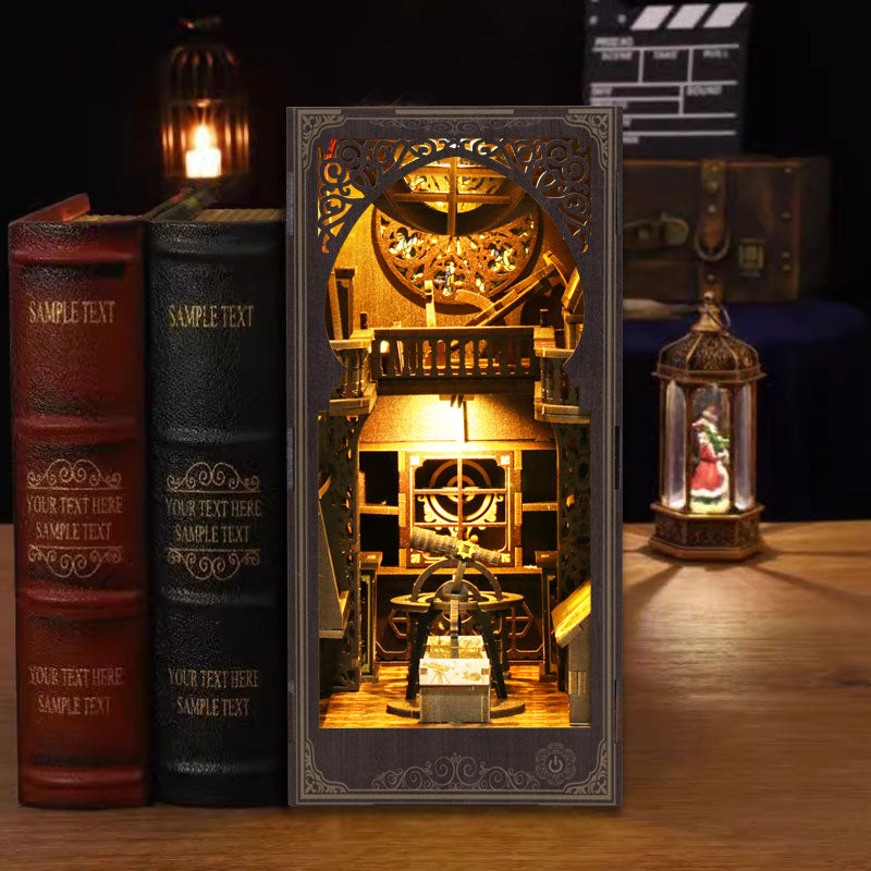 A three-dimensional book-like structure with intricate details, illuminated by a warm light, placed on a wooden surface next to two books and a lantern.