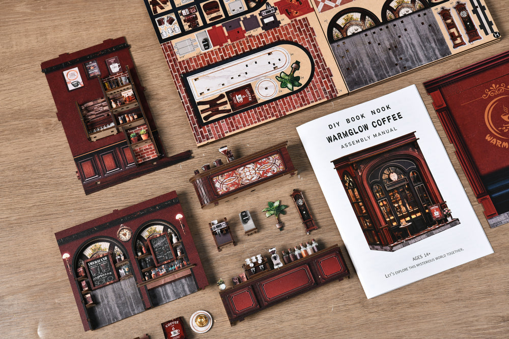 DIY book nook coffee shop kit pieces and instruction booklet laid out on a table