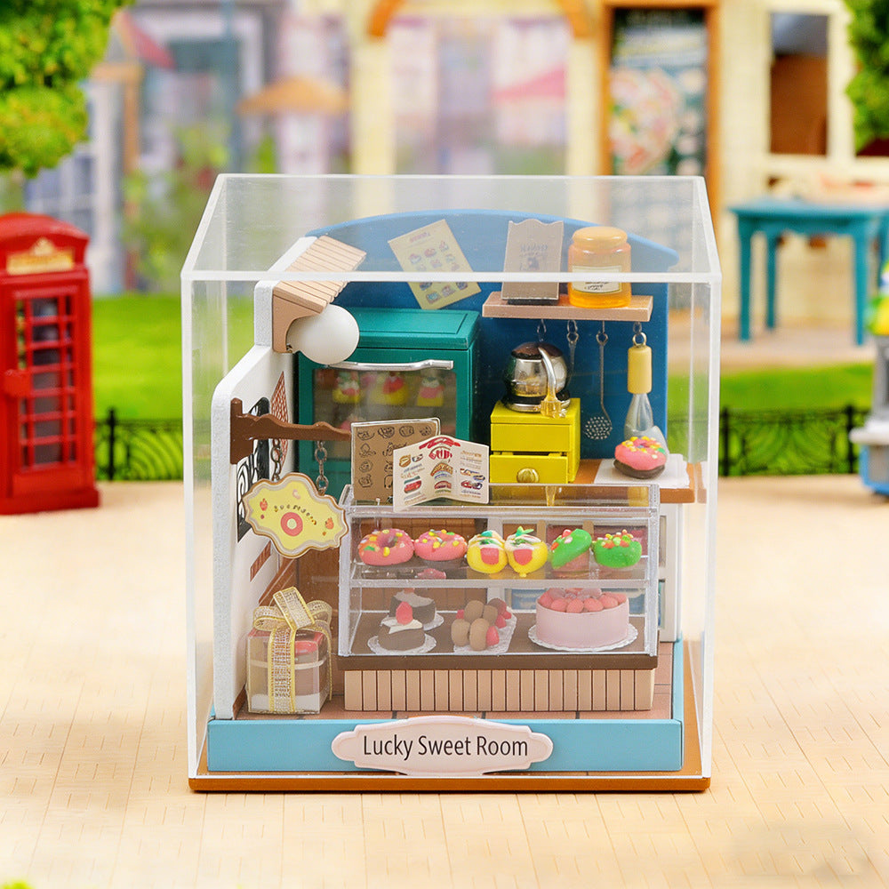 Miniature wooden sweet shop kit inside clear display cover with lit front counter