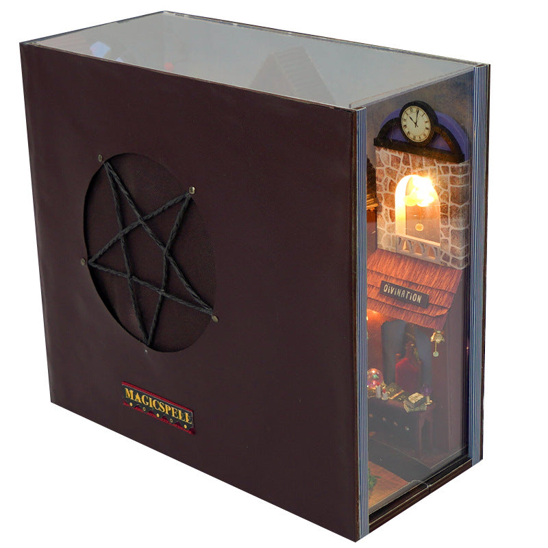 Miniature book nook kit in a display box with glowing window and fireplace scene