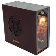 Miniature book nook kit in a display box with glowing window and fireplace scene