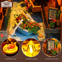 Miniature courtyard scene with potted flowers, lit details, and small planters