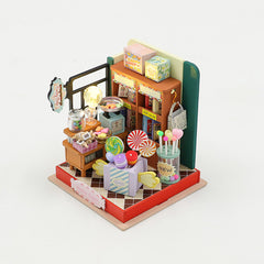 Miniature candy shop diorama with lights, wooden shelves, counters, and candy props