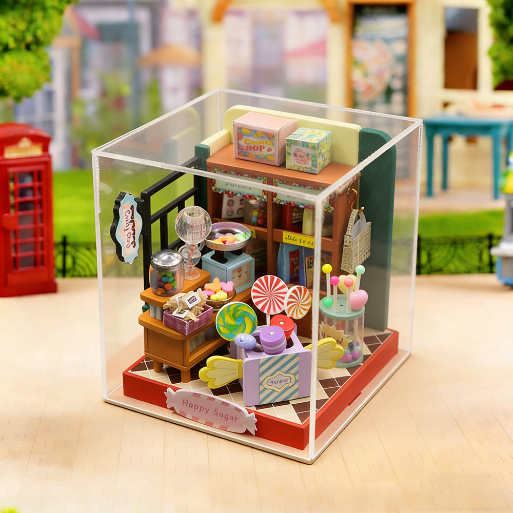 Miniature candy shop diorama in clear display case with lights and colorful candy decor