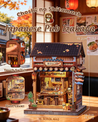Miniature wooden pub-style building with warm-lit interior, hanging lanterns, and exterior signage