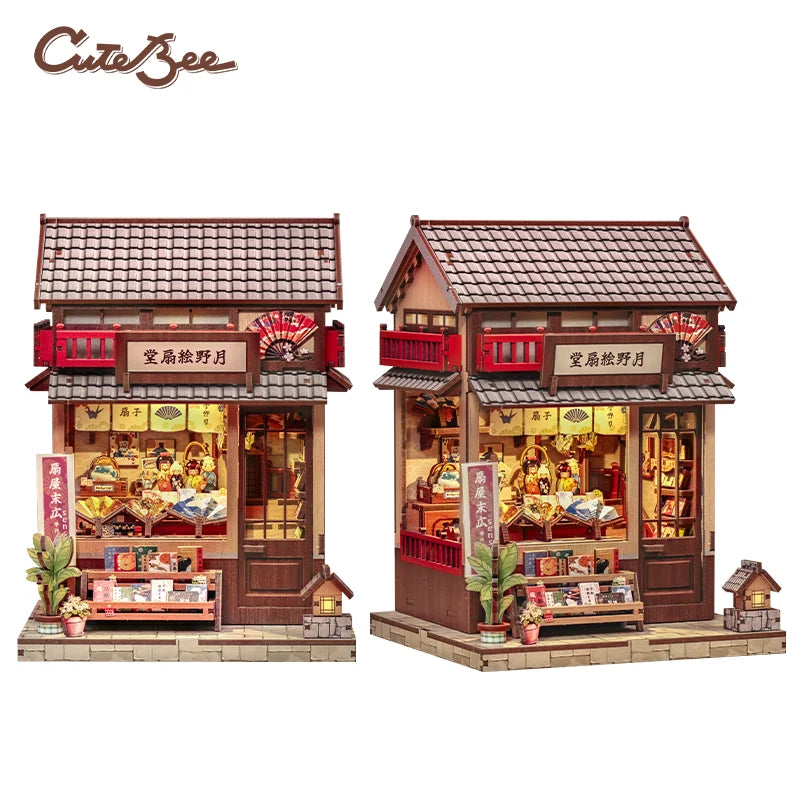 Red miniature wooden shop building with open front and warm interior, shown from two angles