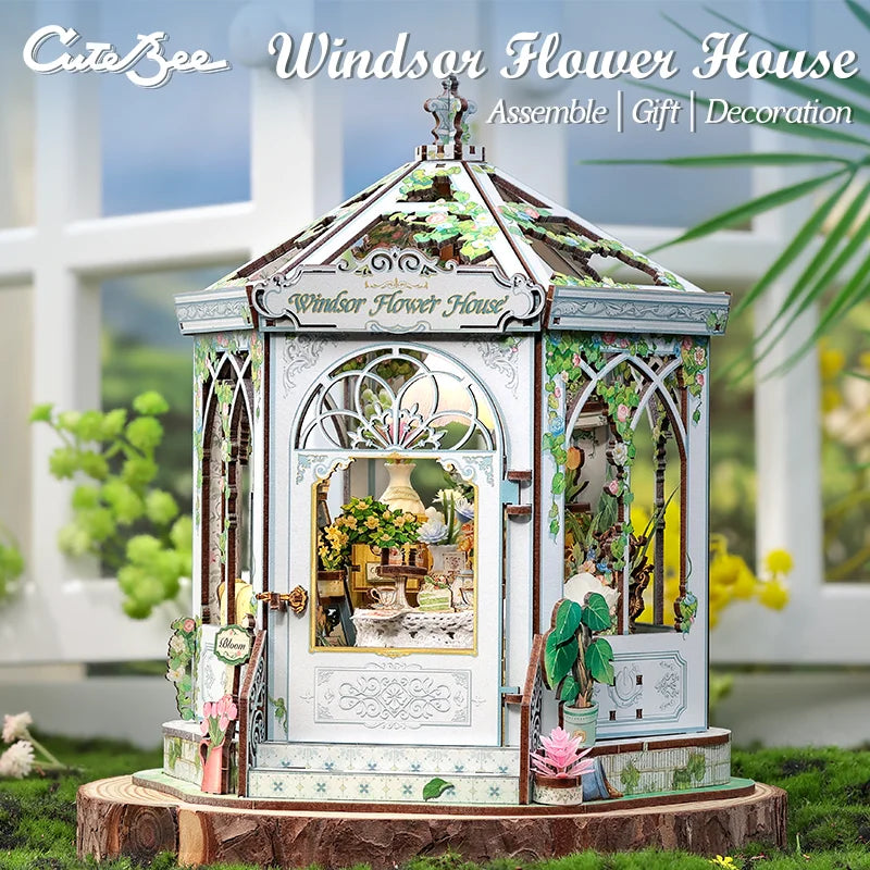 White miniature flower gazebo with arched doors, decorative railings, and warm interior display
