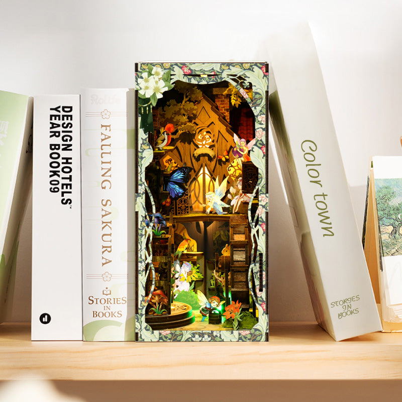 A bookshelf displaying a miniature diorama with a colorful, whimsical scene inside, surrounded by various books.