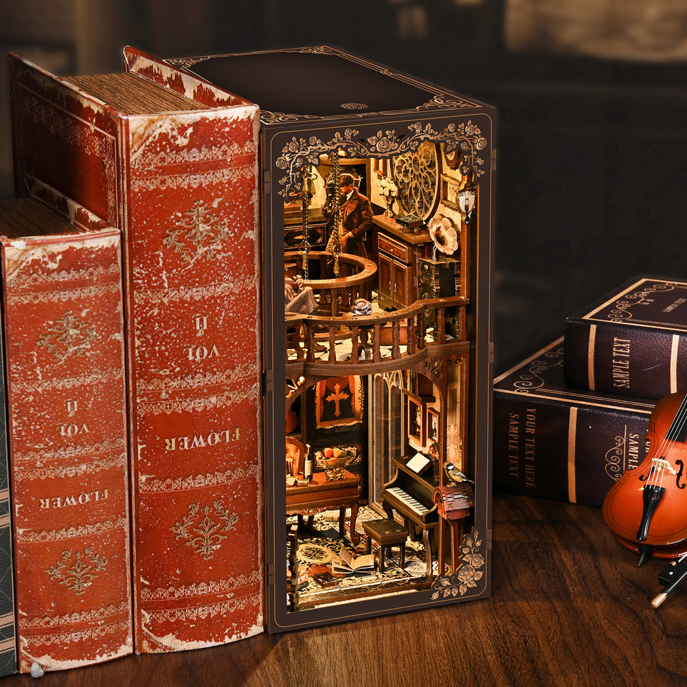 DIY book nook display case with glowing interior beside red decorative book spines