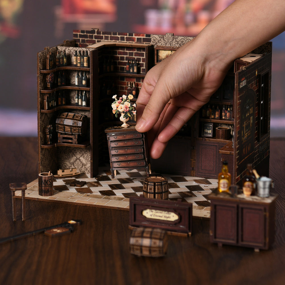 DIY miniature tavern diorama with detailed bar shelves and counter, viewed from front.