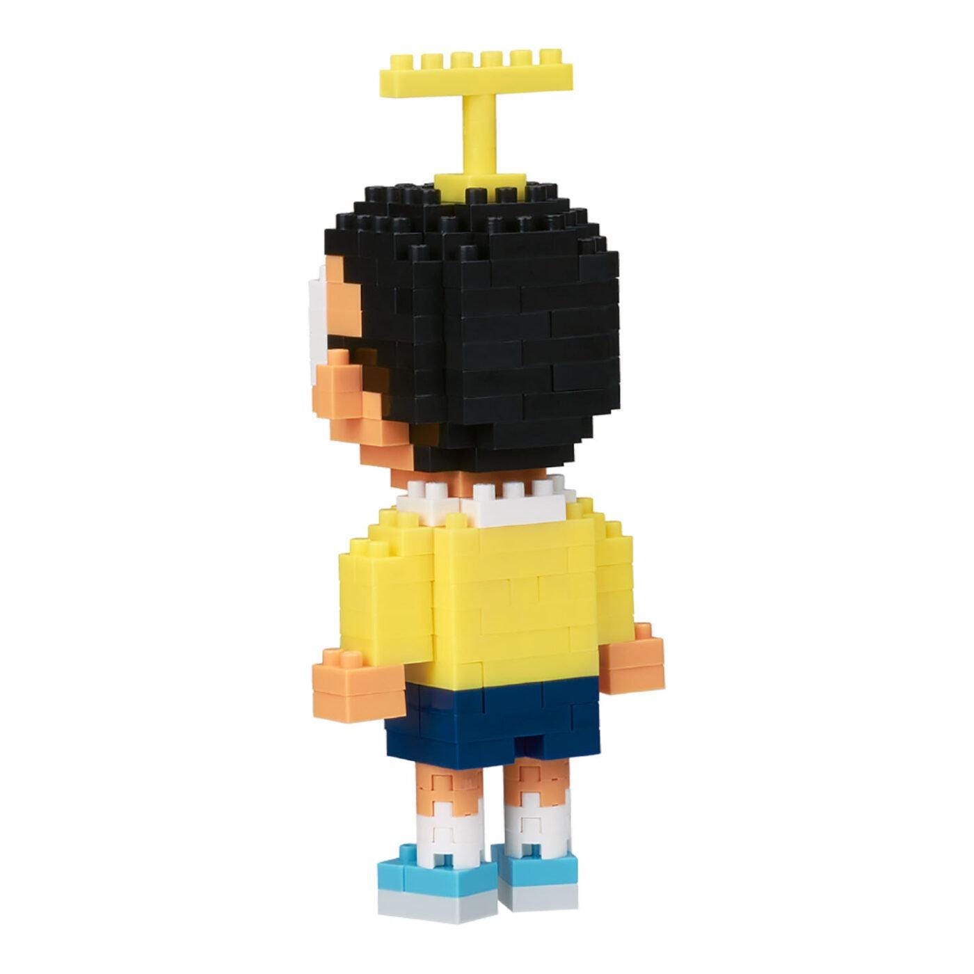 Micro building block figure of a boy with black hair, yellow shirt, blue shorts