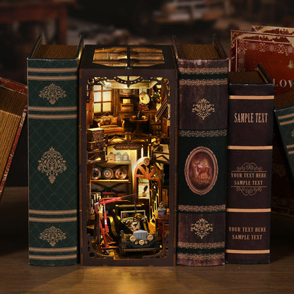 A miniature model of a library or bookcase, with various books and decorative elements, such as a clock and a small car, inside a wooden frame.