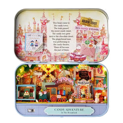 Miniature candy shop diorama inside an open metal case with colorful toy houses