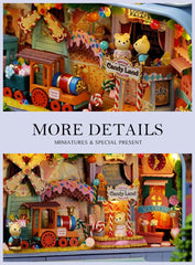 Miniature candy shop diorama with stage sign and toy train, front view