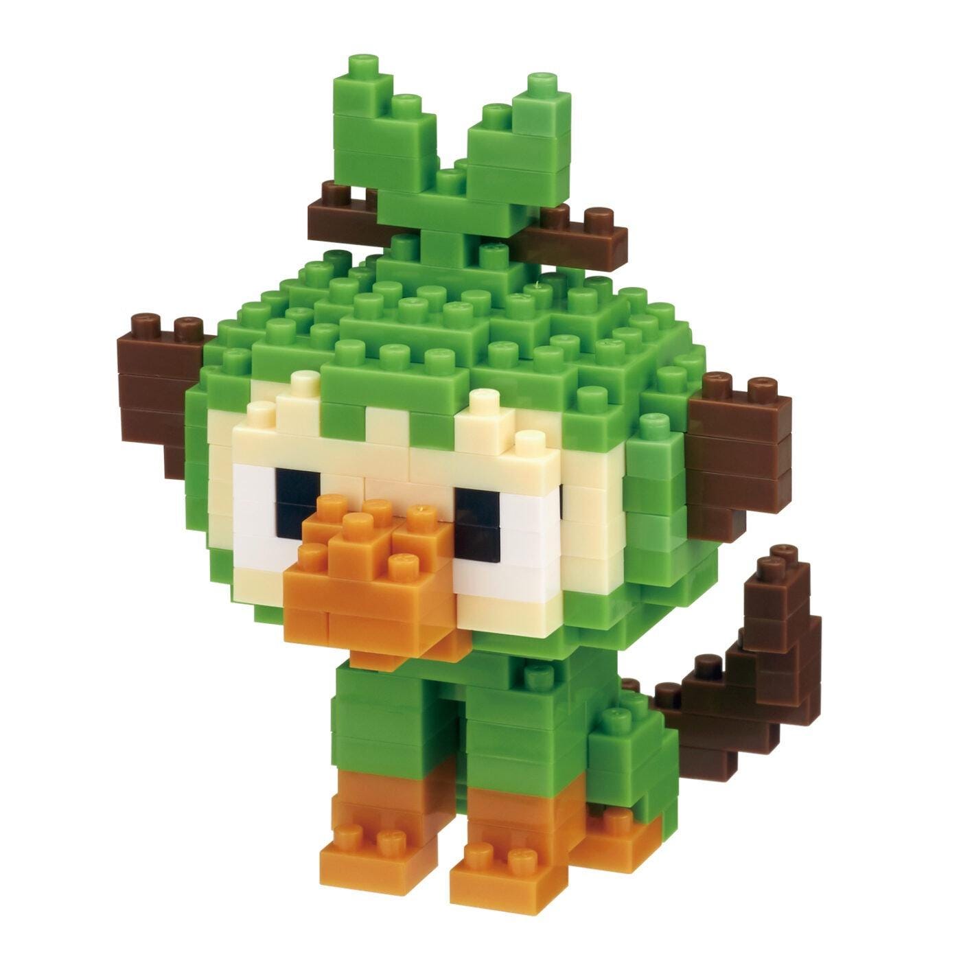 A pixelated toy resembling a monkey or a bird, composed of small green and brown blocks, is shown against a white background.