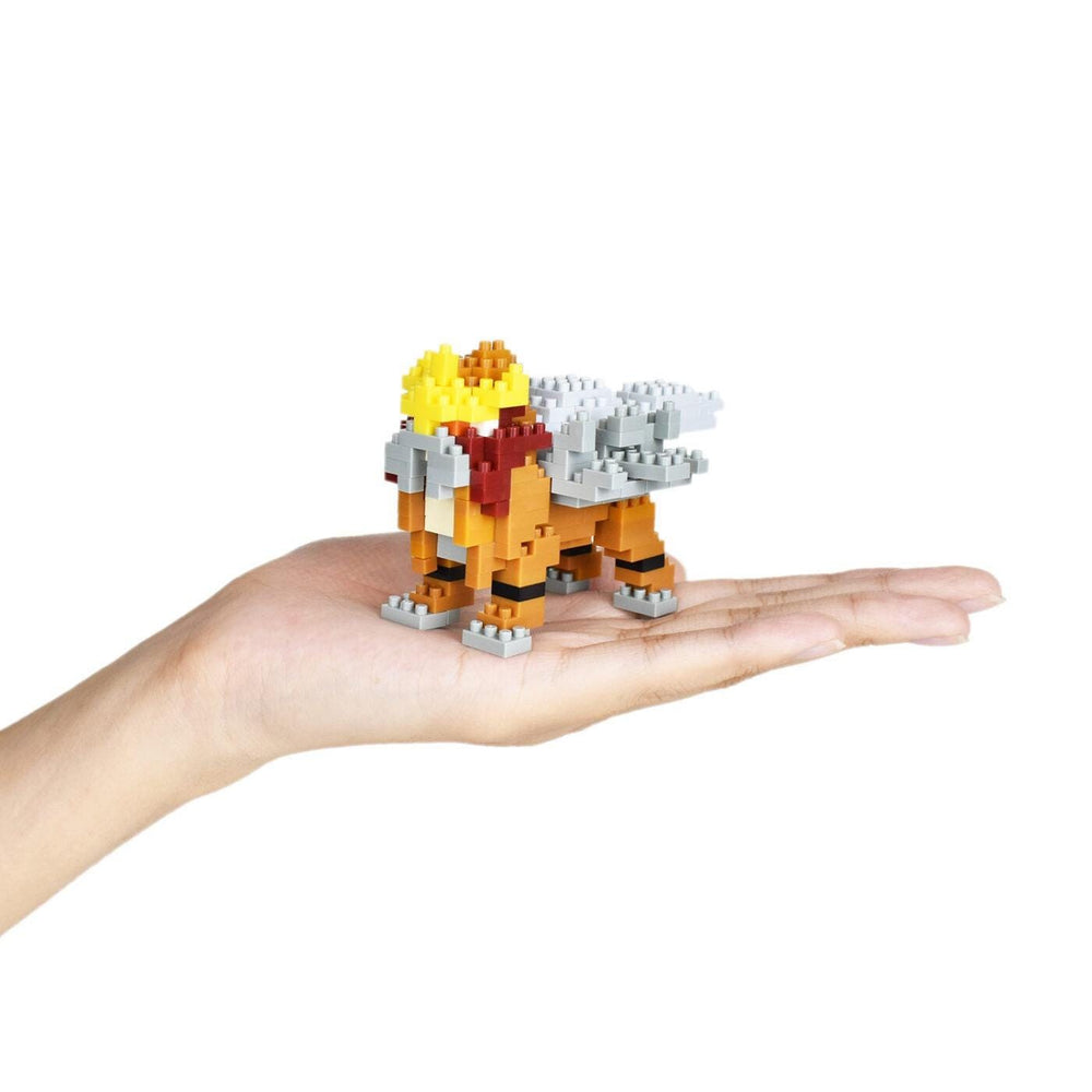 A hand holding a small, colorful, and intricate toy made of small building blocks.