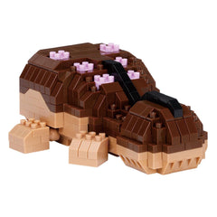A brown and beige Lego toy resembling a small animal or creature, with pink Lego bricks scattered across its body.