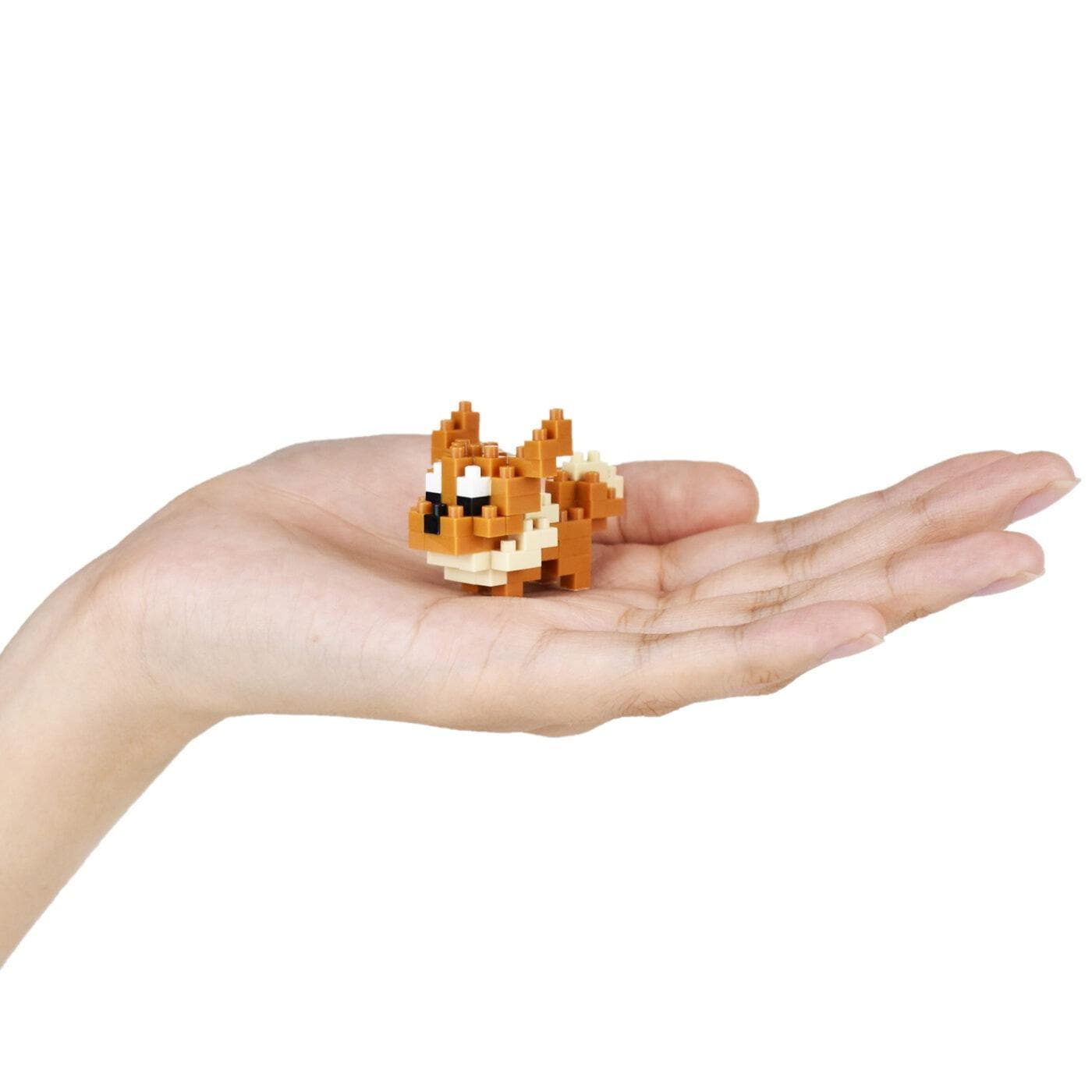 A hand holding a small, pixelated dog-like figure.
