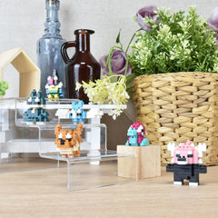 a collection of small, colorful, pixelated figurines or toys arranged on a wooden surface, along with various decorative items such as a vase with flowers and a woven basket.