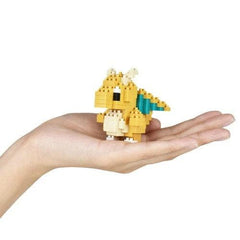 A hand holding a small yellow and green pixelated dragon figure.