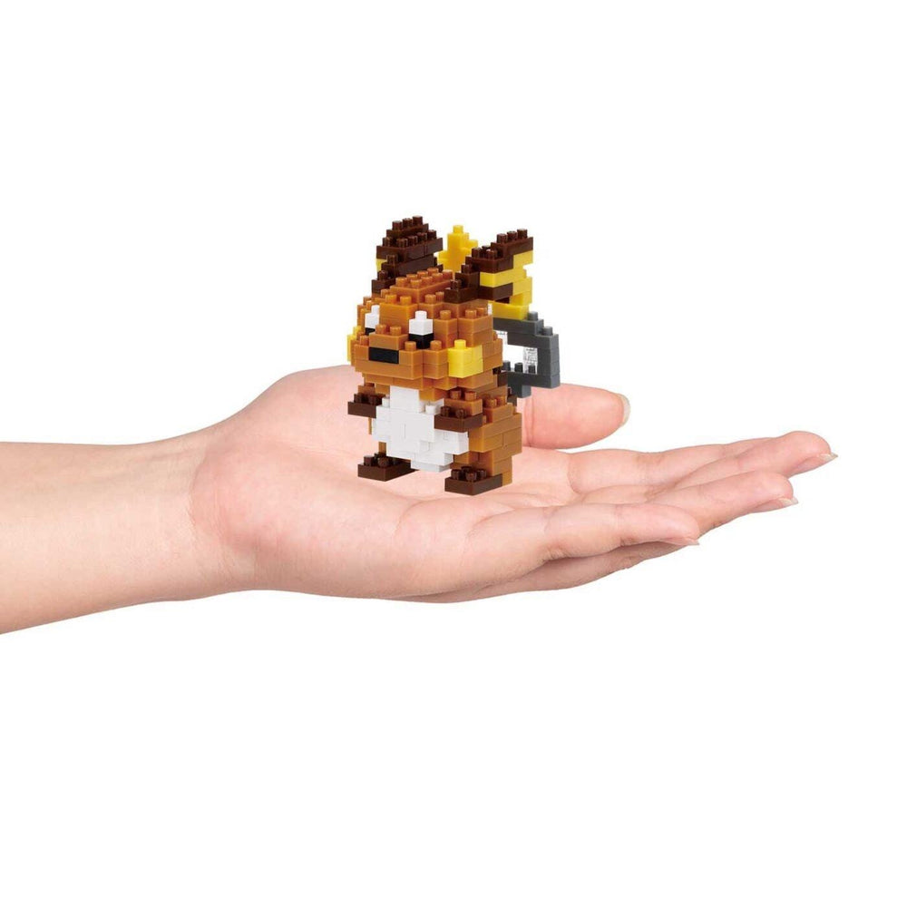 A hand holding a small, pixelated toy resembling a character from a video game.