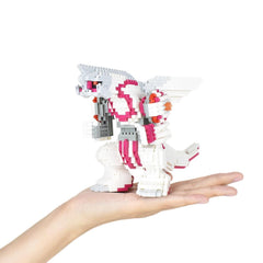 A hand holding a small, colorful, and intricate toy made of small building blocks.