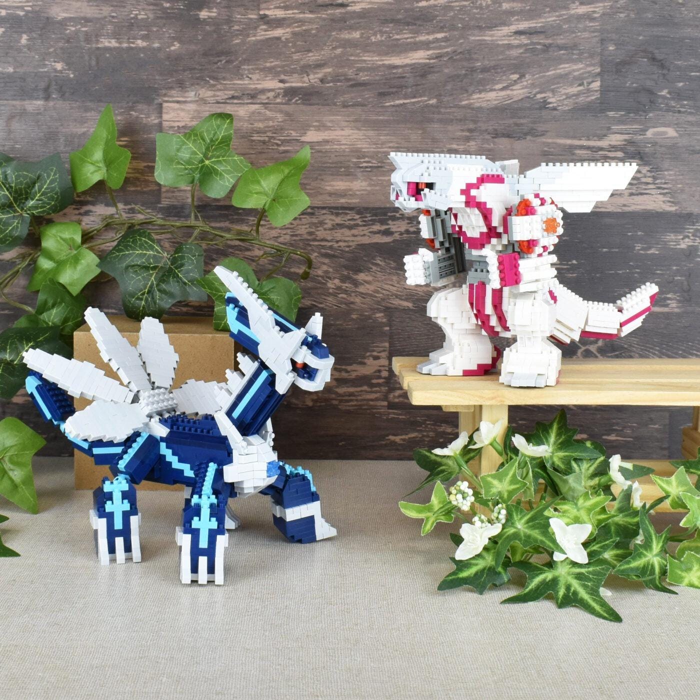 two LEGO figures, one in blue and the other in white, standing on a wooden surface. There are also some plants and flowers in the background.