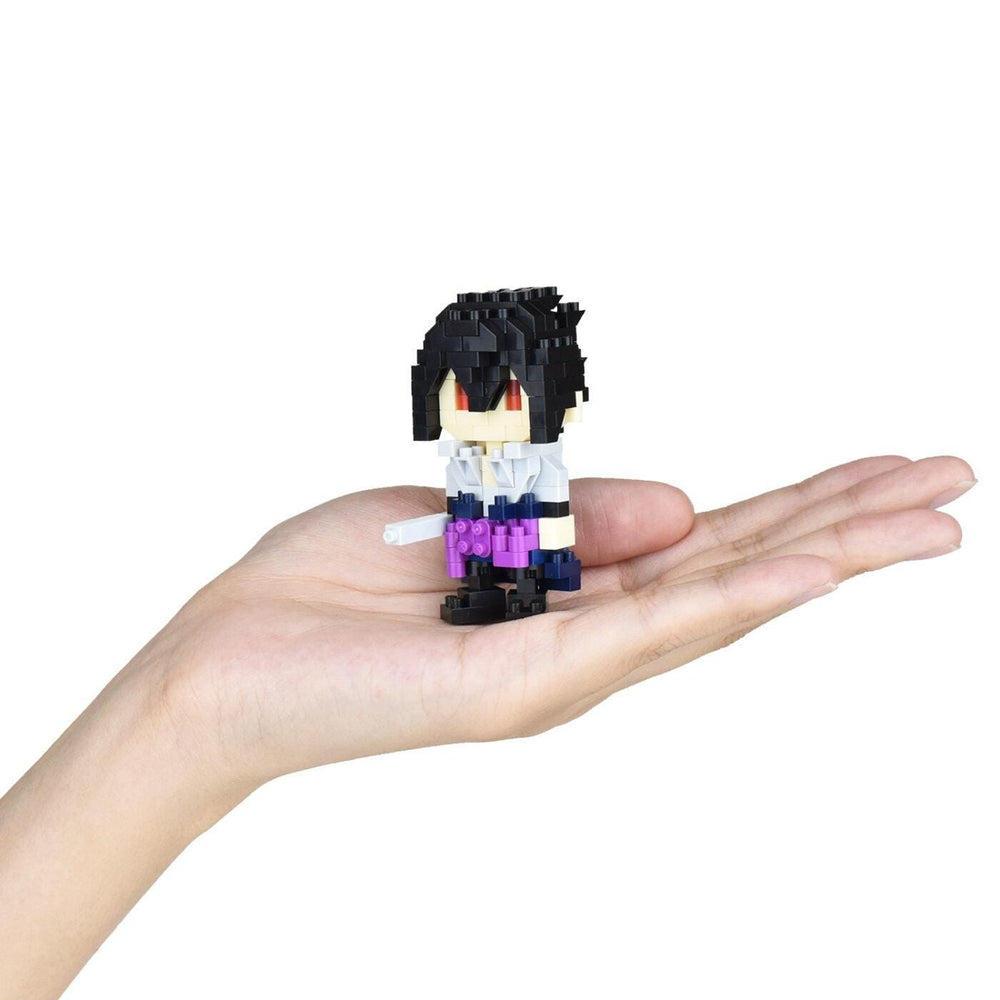 A hand holding a small, pixelated figure of a character with black hair and red eyes.